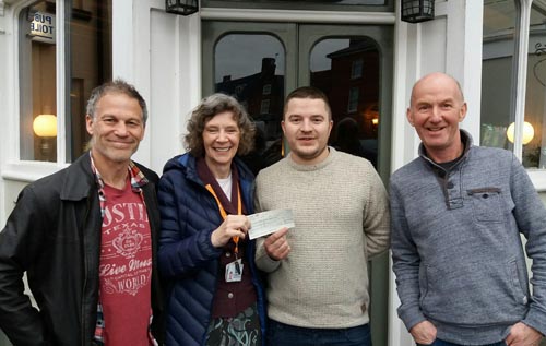 Owen Adcock giving a cheque for '£700 to Mavis Thomson on behalf of Priscilla Bacon Lodge, with Nick Bowden (right) and Steve Plackett (left) representing Reepham Runners. Image: supplied