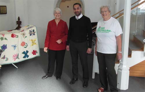 Left to right: Brenda Palmer, Guppy Kular and Pauline Cooper with the quilt made by the Busy Fingers Craft Group, which was raffled in aid of Macmillan Cancer Support