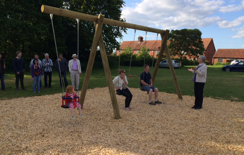 Revd Margaret Dean (right) blessing the new swings at Salle, which are being tested by Jason Greves, chairman of Salle Parish Council, with his wife Clarissa and daughter Daisy